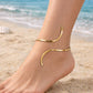 A sleek, architectural gold-toned anklet that hugs the ankle with a minimalist open-ended style, making it the ideal statement piece for a chic rooftop dinner or a stylish city night out.