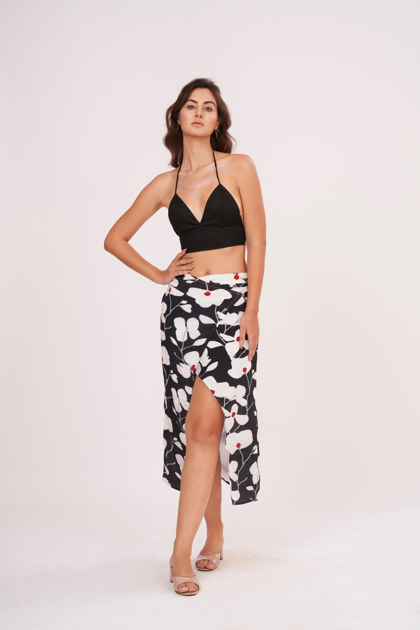 High-waisted wrap-style skirt highlighting a thigh-high front slit and breezy fabric movement for summer wear.