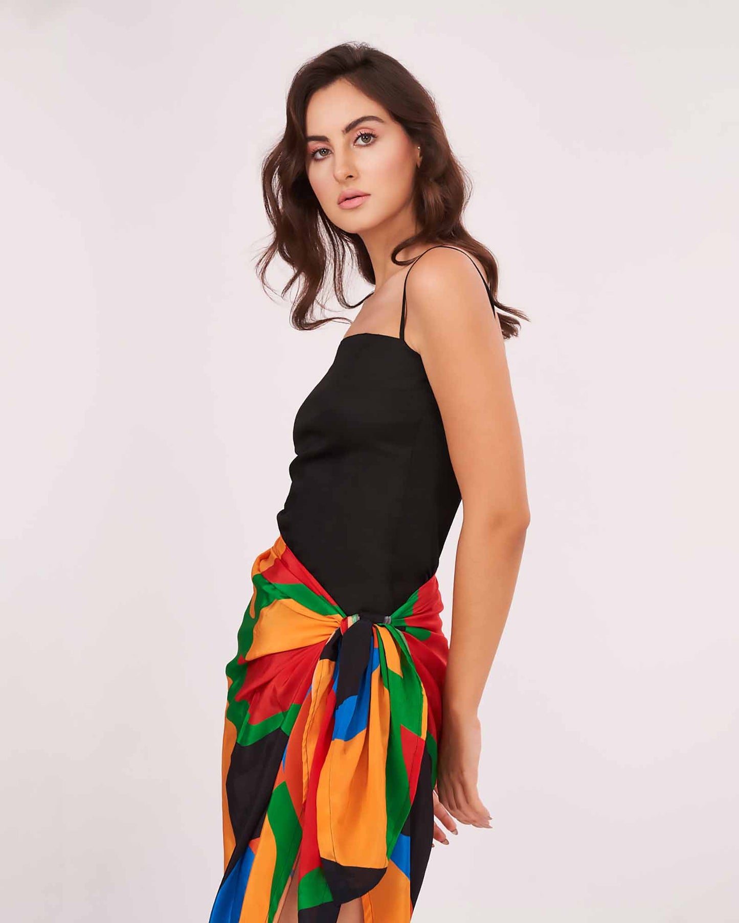 Vibrant two-piece look pairing a sleek black cami with a colorful wrap skirt tied at the waist. The Sexy Sarong Dress is designed for effortless style on sunny getaways.