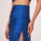 Close-up of the gathered waistline and ruching details on the satin-finish skirt, emphasizing the high side slit construction.