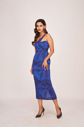 Form-fitting midi silhouette showcasing the complete botanical print layout against the vibrant royal blue backdrop. 