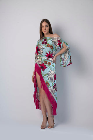 Walking pose of model in asymmetric hem beach dress with playful fringes and bohemian print, hands gently at sides.