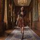 Multi-colored abstract geometric print in warm earth tones of rust, ochre, and deep teal, accented by sharp black lines throughout the bodice and skirt.