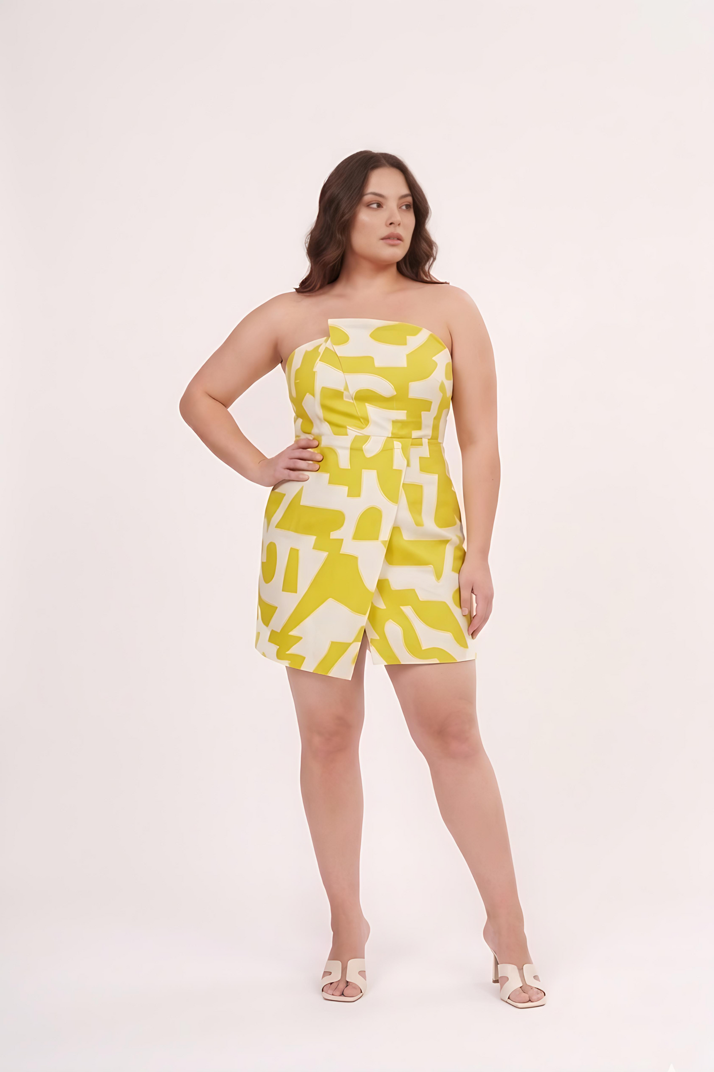 Close-up of elasticated tube neckline with cut accents on a lime yellow geometric muslin midi dress