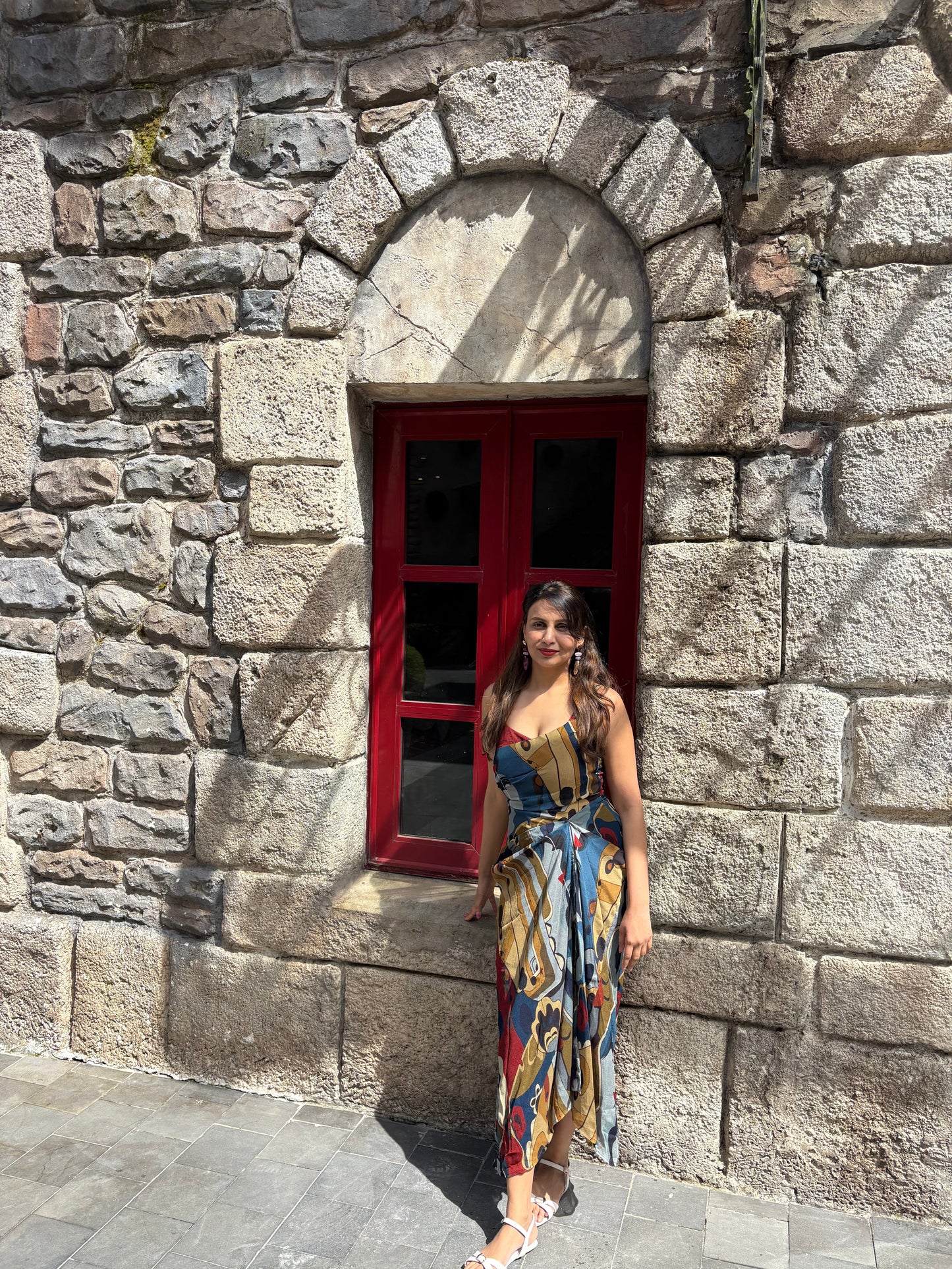 Flowy chinon midi dress with multicolor abstract print and subtle front slit, ideal for holiday and day-to-evening styling