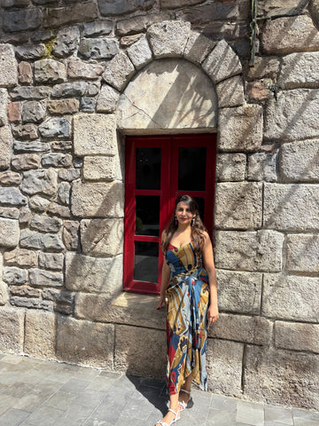 Flowy chinon midi dress with multicolor abstract print and subtle front slit, ideal for holiday and day-to-evening styling