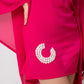 Side close-up of shell-detailed embroidery and lace design on pink kaftan dress hem.