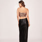 Back view of a faux leather co-ord set with a tube top and black skirt featuring a back zip closure