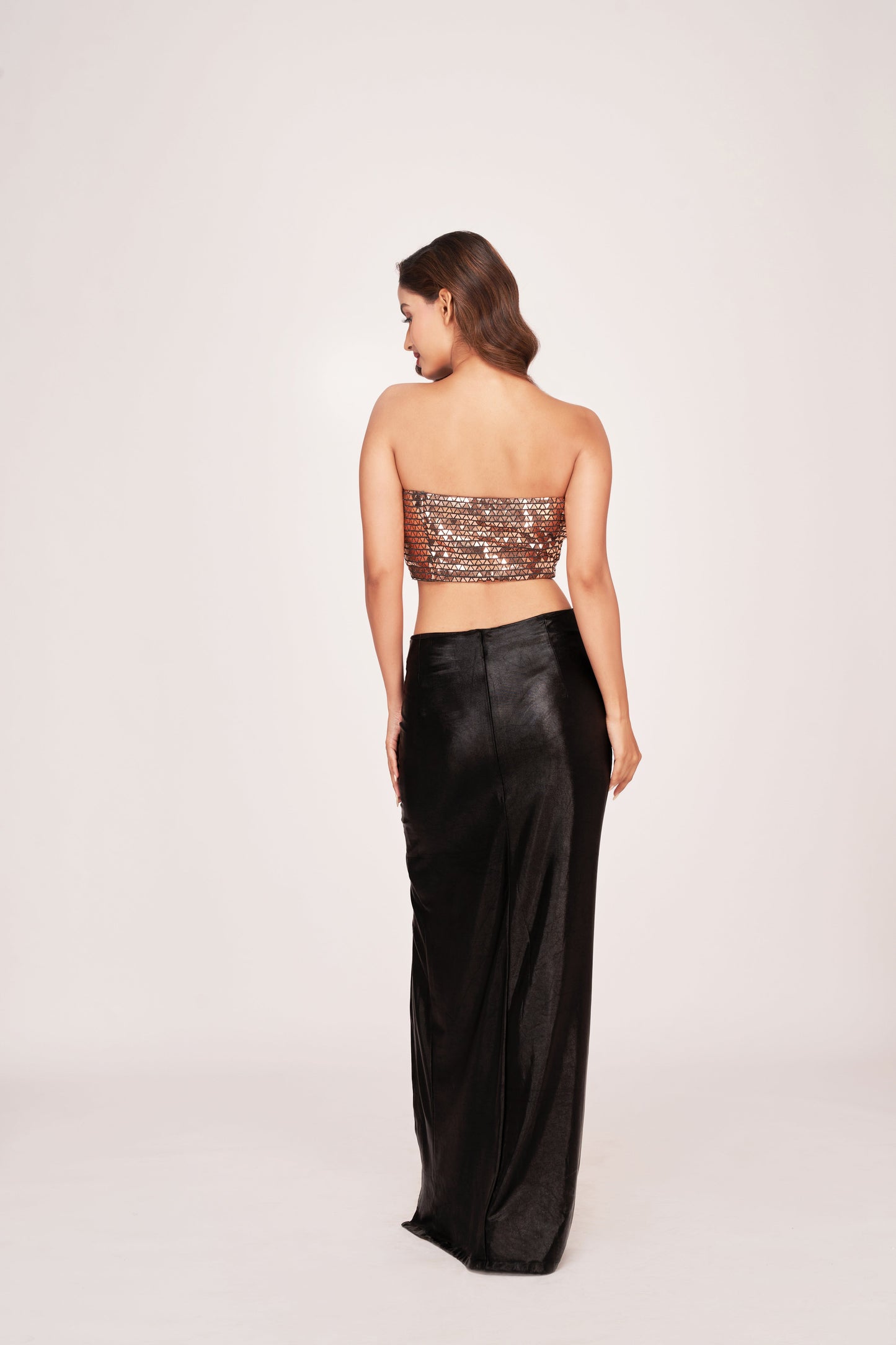 Back view of a faux leather co-ord set with a tube top and black skirt featuring a back zip closure