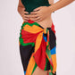 Geometric print wrap skirt in vibrant orange, red, and black featuring a side-knot waist detail and high slit.