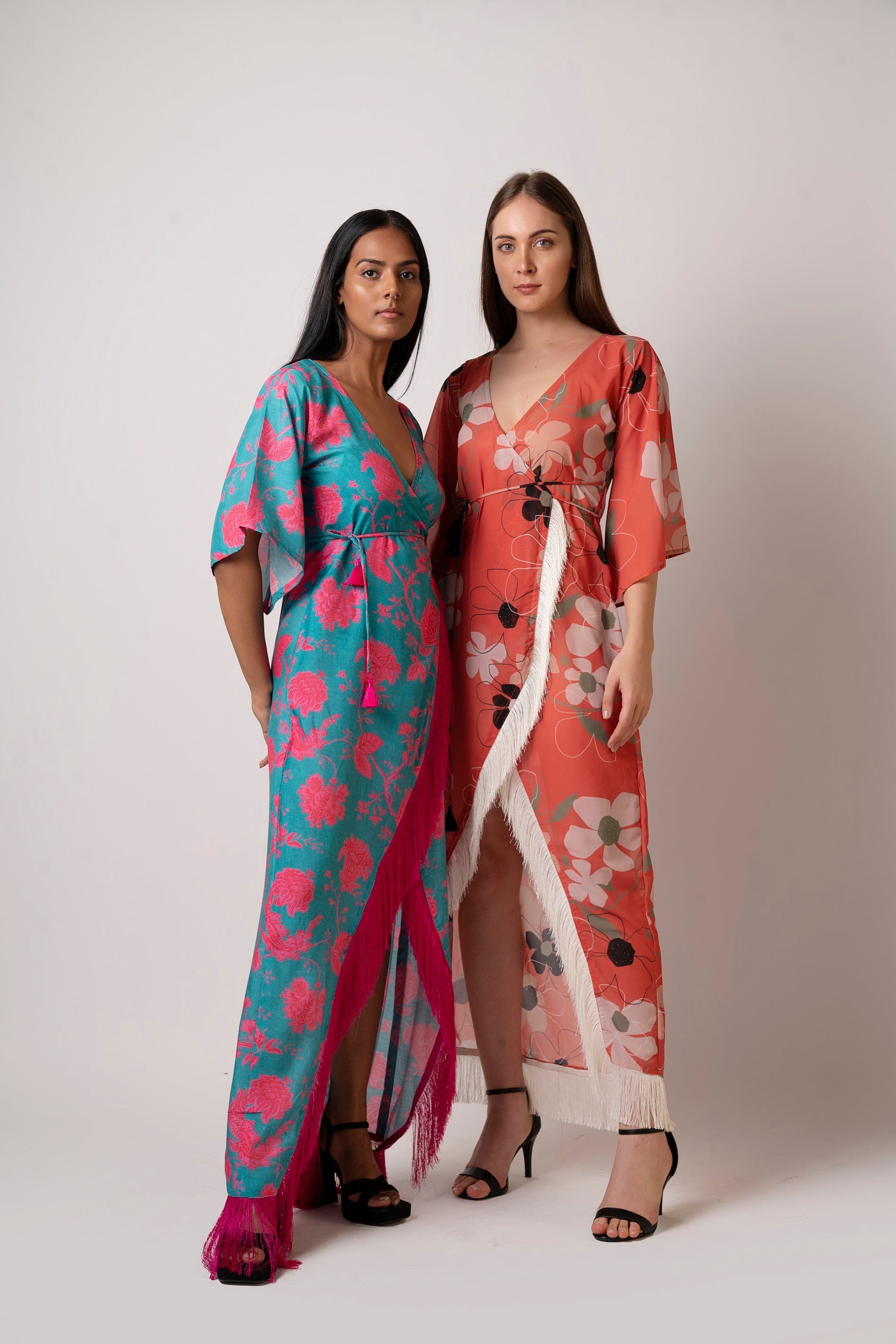Standing pose of model in blue floral muslin wrap dress with arm at the back, emphasizing structure and relaxed fit