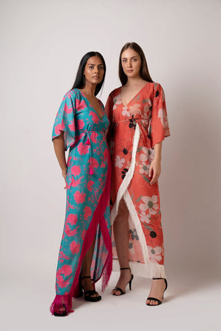 Standing pose of model in blue floral muslin wrap dress with arm at the back, emphasizing structure and relaxed fit