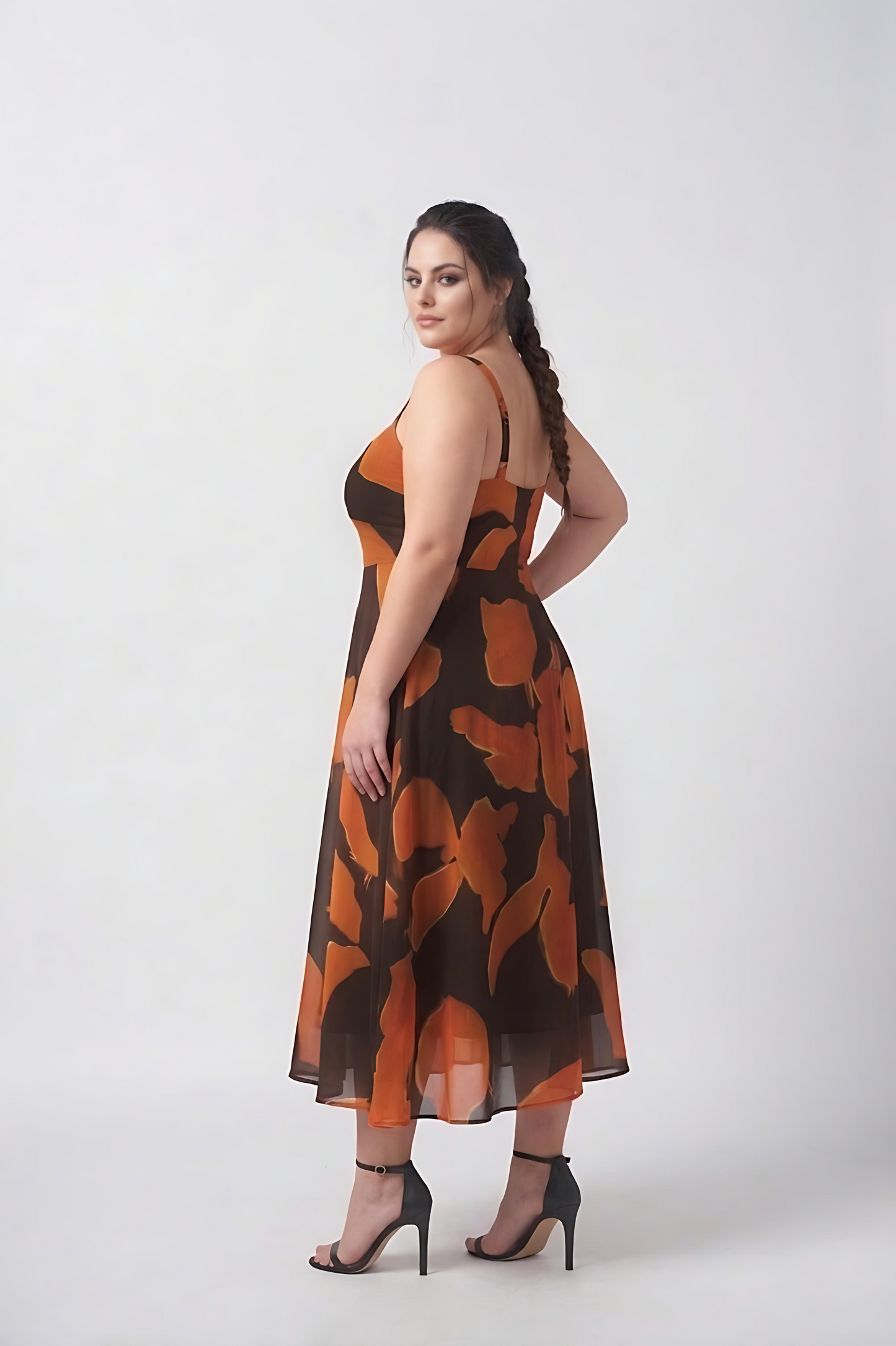 Close-up of orange and brown abstract print on smooth crepe midi dress with a fluid drape