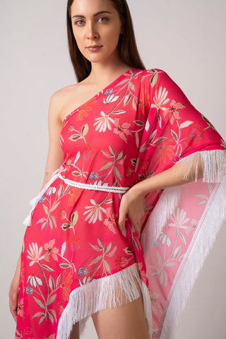 Close-up of model in pink one-shoulder georgette dress with tassel belt and kaftan sleeve, hand resting on hip.
