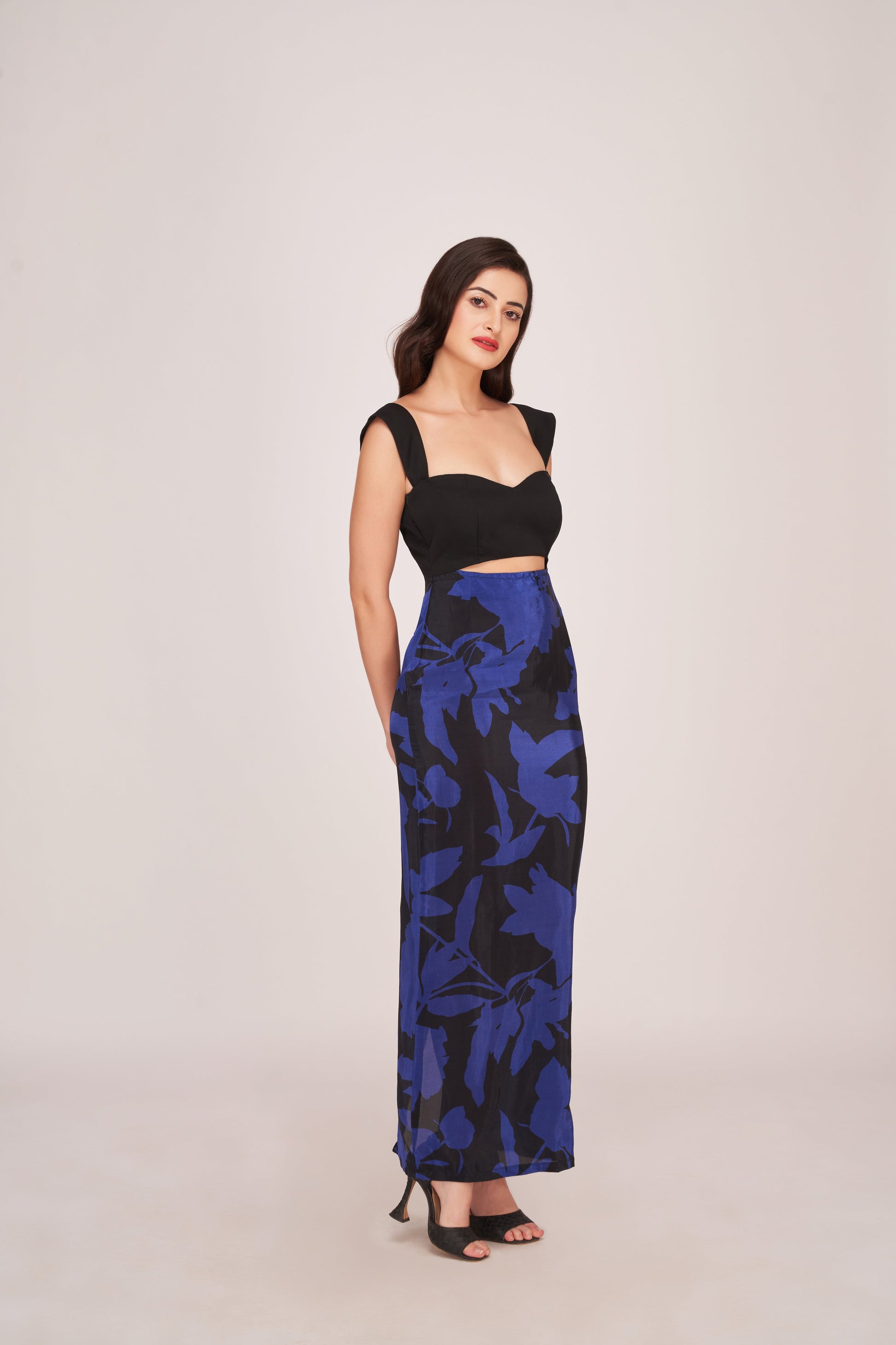 Full-length maxi silhouette featuring a solid black top contrasting with a royal blue and black floral printed skirt. 