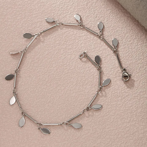 This high-shine silver charm anklet offers a clean and modern aesthetic, designed to be a versatile staple that elevates both your professional office attire and your favorite holiday outfits.