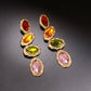 A pair of striking drop earrings featuring a bold color-block design with segments of translucent amber, deep teal, and clear glass, perfect for adding a sophisticated pop of color to a creative office look or an art gallery visit.