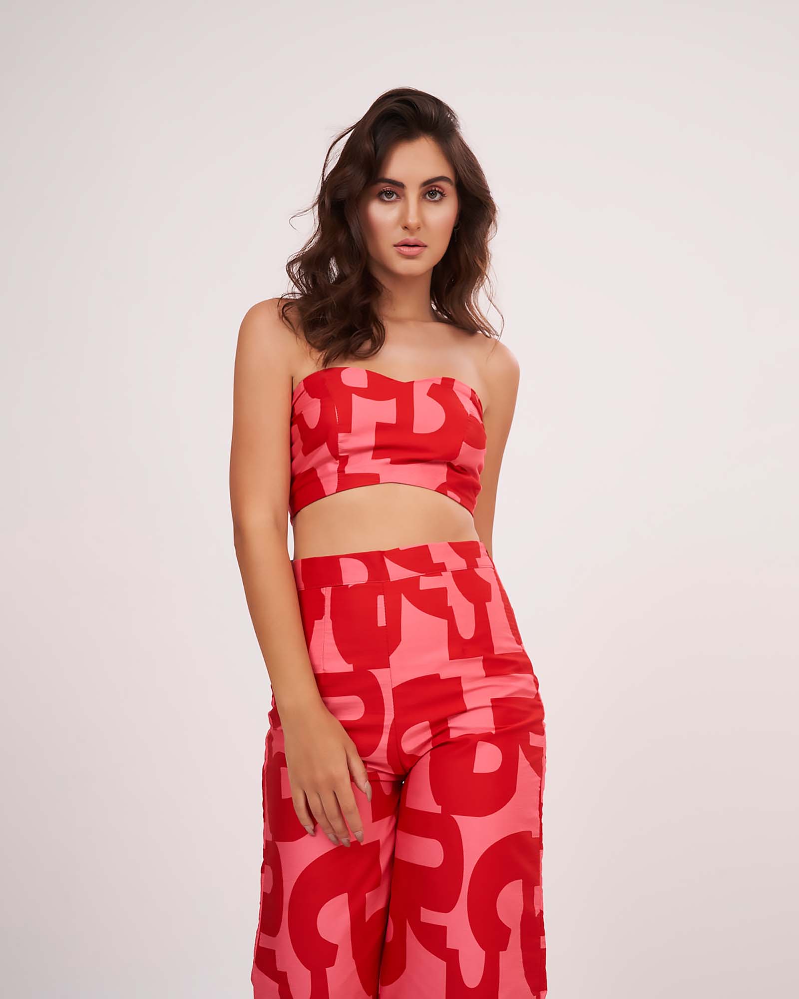 Graphic print ensemble in vibrant red hues, combining a fitted bodice with relaxed flowy bottoms for a chic look.