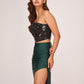 Side profile showcasing the texture of the noir top and the elegant drape of the verde green skirt against the body.