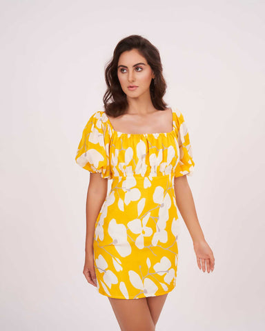 Yellow printed dress, showcasing movement and flared silhouette with puffed sleeves.