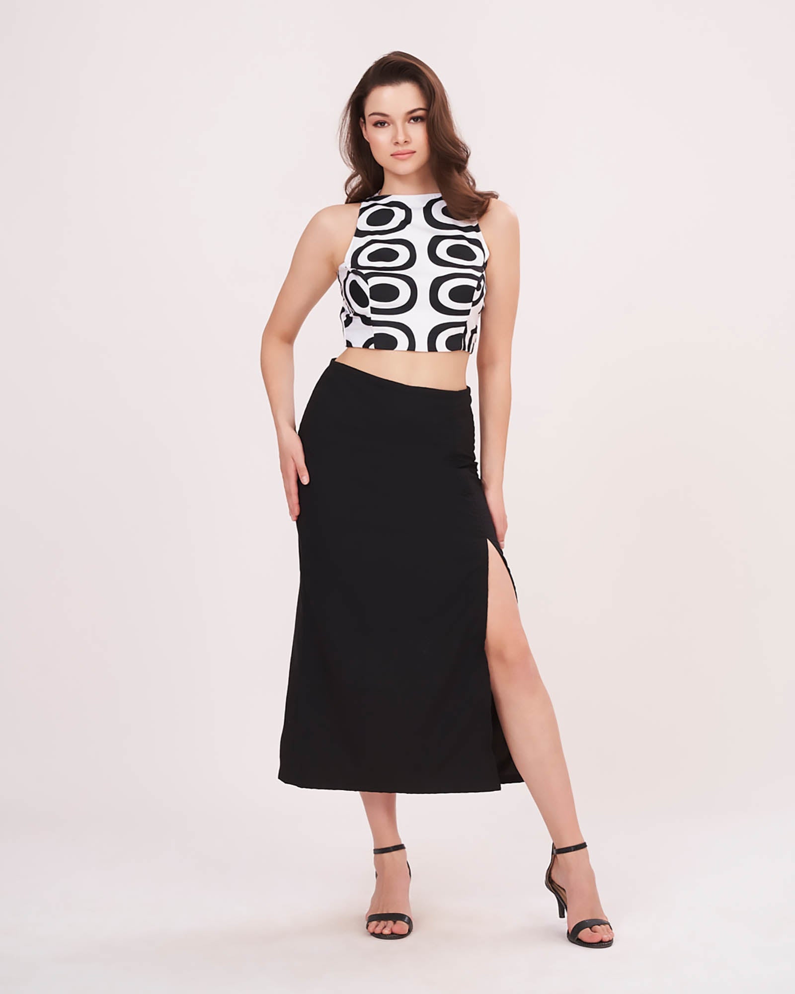 Solid black midi skirt highlighting a daring thigh-high side slit and a sleek, fitted silhouette.